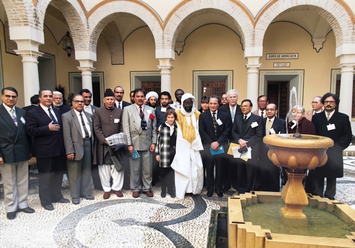 Academy members and guests gathered in a courtyard in Andalusia, Spain, with Moorish arches behind them.